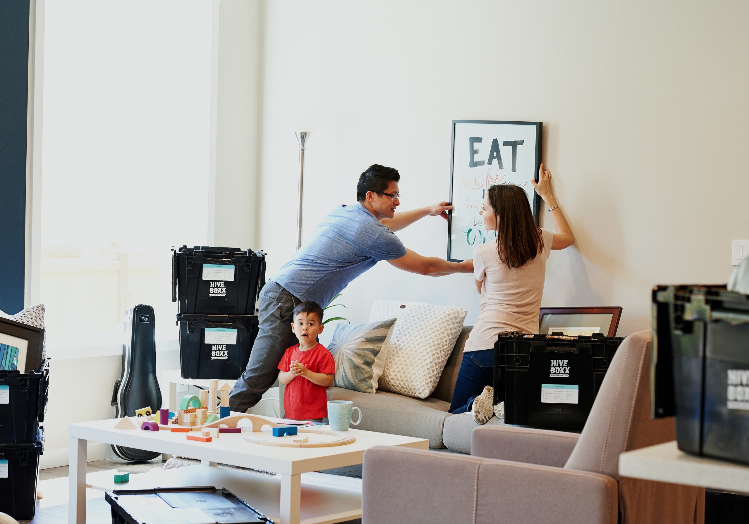 a couple taking art off of their wall for moving